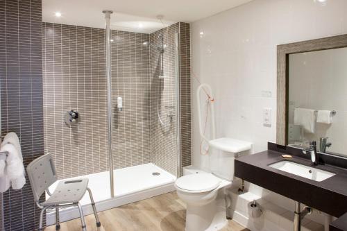 a bathroom with a shower and a toilet and a sink at Holiday Inn Norwich North by IHG in Norwich