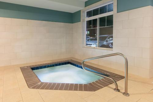 a hot tub in a room with a window at Holiday Inn Express Hotel & Suites Seaside Convention Center by IHG in Seaside