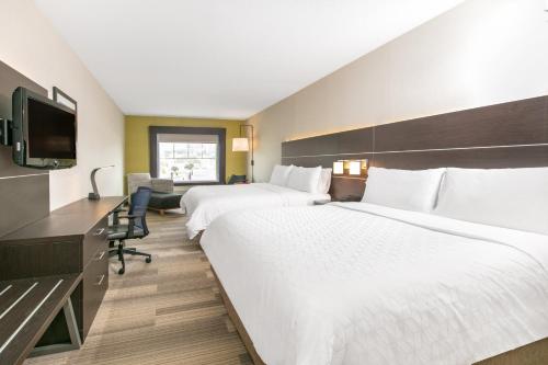 a hotel room with two beds and a desk at Holiday Inn Express Hotel & Suites Seaside Convention Center by IHG in Seaside