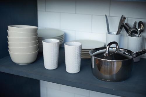 a counter with cups and plates and a pot at mizuka Imaizumi 1 - unmanned hotel - in Fukuoka