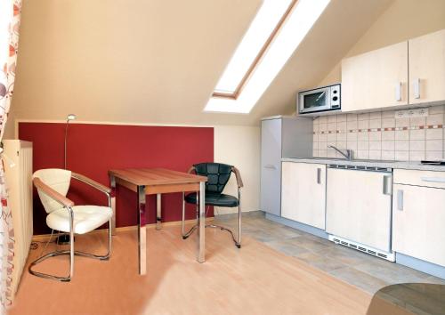 uma cozinha com mesa e cadeiras num quarto em Ferienwohnungen Am Lotsenstieg Morgensonne em Timmendorf