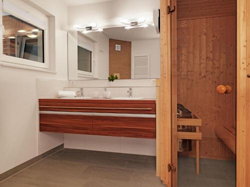 ein Bad mit einem Waschbecken und einem Spiegel in der Unterkunft Haus Südwester Austernperle in Timmendorf
