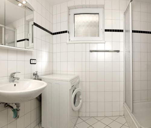 een witte badkamer met een wastafel en een wasmachine bij Seerose in Insel Poel