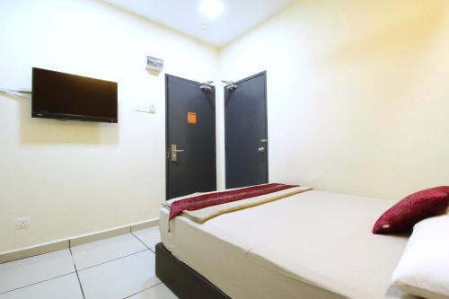 a bedroom with a bed and a flat screen tv at Mimilala Hotel @ i-City, Shah Alam in Shah Alam