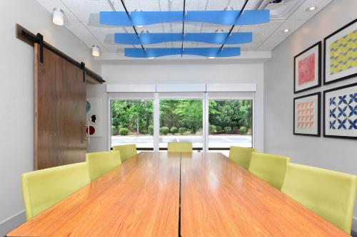 a conference room with a wooden table and yellow chairs at Holiday Inn Express & Suites Raleigh Durham Airport at RTP by IHG in Durham