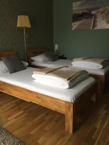 2 łóżka pojedyncze w pokoju z lampką w obiekcie B&B Alex18 w Niszu