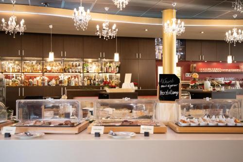 eine Bäckerei mit einer Theke mit Tabletts mit Gebäck in der Unterkunft Bergwirtschaft Wilder Mann Hotel und Restaurant in Dresden