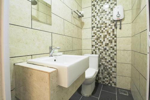 uma casa de banho com um lavatório e um WC em Mimilala Hotel @ i-City, Shah Alam em Shah Alam