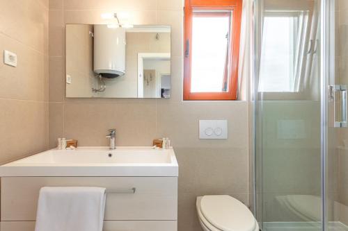 a bathroom with a sink and a toilet and a mirror at Apartments Mike in Malinska