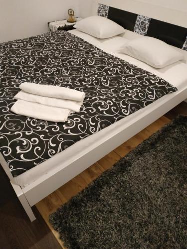 a bed with black and white sheets and towels on it at Гостьовий дім у Почаєві in Pochayiv
