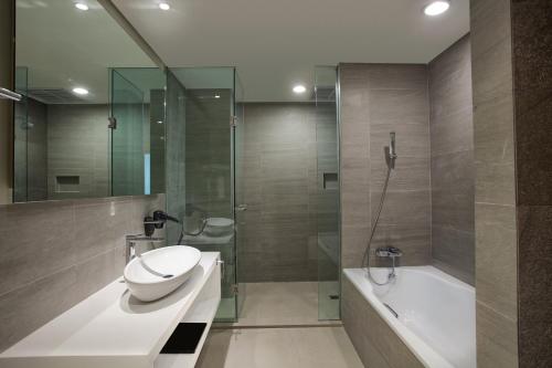 La salle de bains est pourvue d'un lavabo, de toilettes et d'une baignoire. dans l'établissement Grand Safran Hotel Pangkalpinang, à Pangkal Pinang