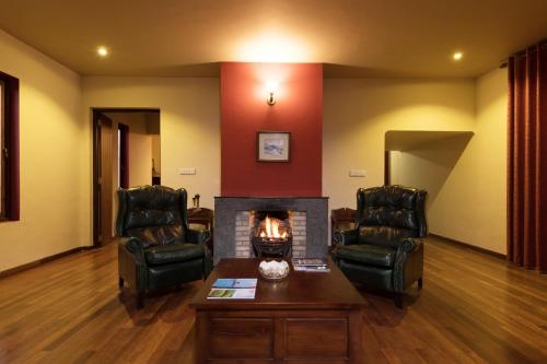 a living room with two chairs and a fireplace at The Walden Nuwara Eliya in Nuwara Eliya