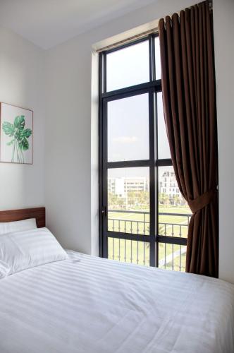 a bedroom with a bed and a large window at The Flamboyant #StayWork Vinhomes Imperia in Hai Phong