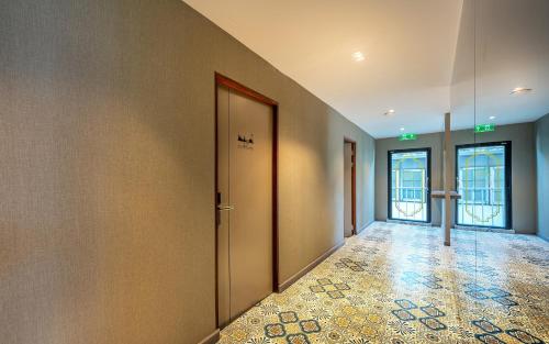 an empty hallway with two doors and a tile floor at Happy Station Bangkok in Bangkok