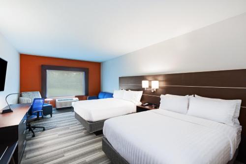 a hotel room with two beds and a desk at Holiday Inn Express & Suites - Coffeyville by IHG in Coffeyville
