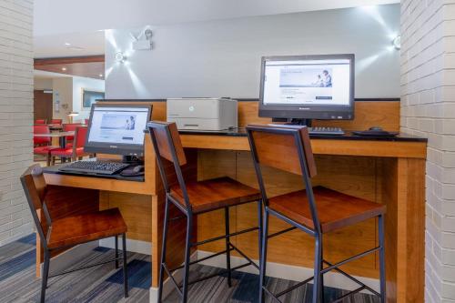 two computer monitors on a desk with two chairs at Holiday Inn Express & Suites Chicago-Midway Airport by IHG in Bedford Park