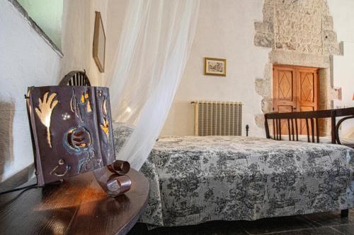 a bedroom with a bed and a wooden chair at Case Brizza in Casale Zappulla
