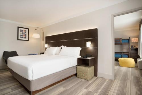 a hotel room with a large bed and a mirror at Holiday Inn Express Hotel & Suites Dallas NE - Allen by IHG in Allen