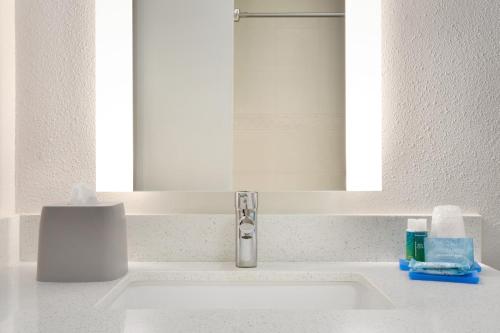 a bathroom sink with a mirror and a white sink at Holiday Inn Express Hotel & Suites Dallas NE - Allen by IHG in Allen