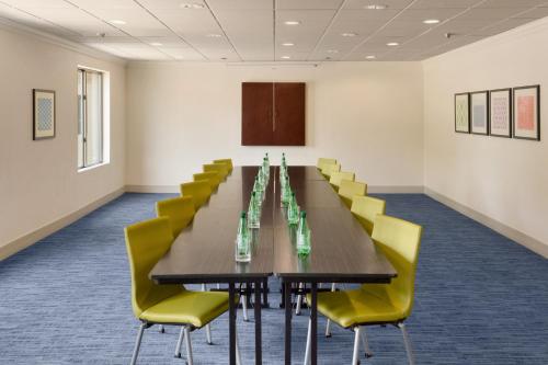 a conference room with a long table and yellow chairs at Holiday Inn Express Hotel & Suites Dallas NE - Allen by IHG in Allen
