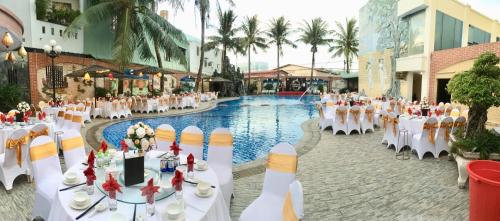 a restaurant with tables and chairs in front of a pool at Muong Thanh Quy Nhon Hotel in Quy Nhon