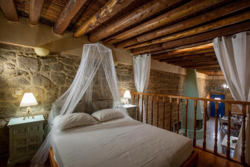 - une chambre avec un lit et une moustiquaire dans l'établissement M-Cube Malona Village House near Lindos, à Malona Village
