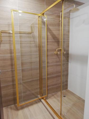 a shower with a glass door in a room at Brisbane Quarters in Brisbane