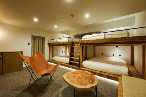 2 Etagenbetten in einem Zimmer mit einem Tisch und einem Stuhl in der Unterkunft mizuka Daimyo 7 - unmanned hotel - in Fukuoka