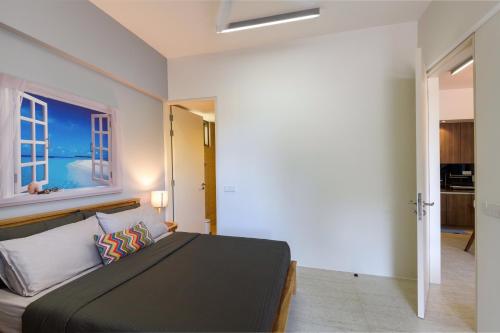 a bedroom with a large bed and a window at By The Sea Beach Front Apartment in Batu Ferringhi