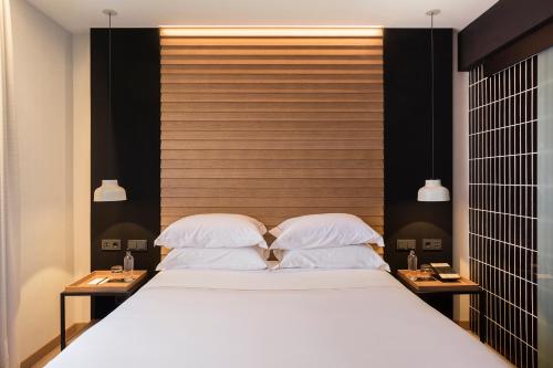 a bedroom with a large bed with two night stands at Casa Elliot Hotel in Barcelona