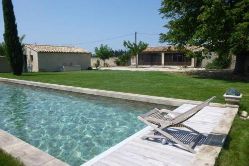 una piscina con terraza y una silla en un patio en charmant loft à la campagne en Cavaillon