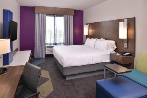 a hotel room with a large bed and a desk at Holiday Inn Express and Suites Bryant - Benton Area by IHG in Bryant