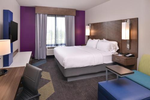 ein Hotelzimmer mit einem großen Bett und einem Schreibtisch in der Unterkunft Holiday Inn Express and Suites Bryant - Benton Area, an IHG Hotel in Bryant