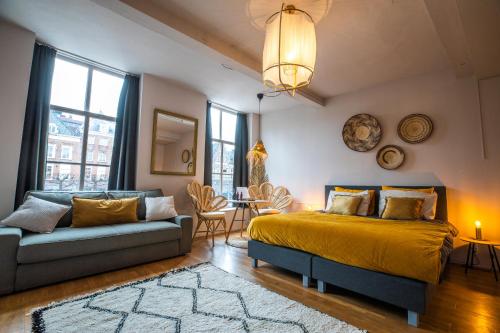 a bedroom with a king sized bed and a couch at Bambu Sleep Boutique in Haarlem