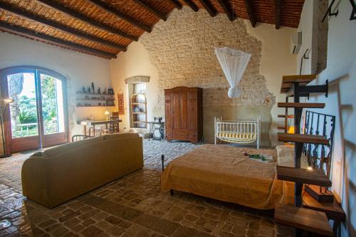 a bedroom with a bed and a couch in a room at Case Brizza in Casale Zappulla