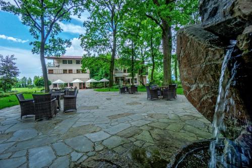 a water fountain next to a stone wall with chairs at Farmona Hotel Business & SPA in Kraków