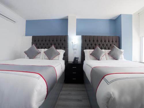 two beds in a room with blue and white at Suites Arboleda 215 in Mexico City