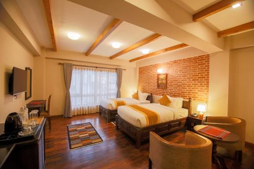 a bedroom with two beds and a brick wall at Hotel Bhadgaon in Bhaktapur
