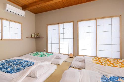 three beds in a room with windows at Kitaguchi Tougakukan in Fujiyoshida