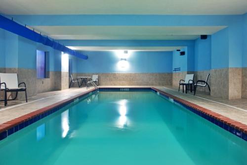 uma piscina num edifício com paredes e cadeiras azuis em Holiday Inn Express Amite, an IHG Hotel em Amite