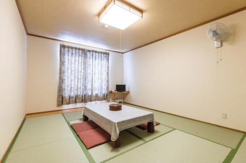 um quarto vazio com uma mesa e uma janela em Tabist Matsushima Onsen Otomenoyu Sakurashi em Sakura