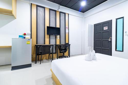 a room with a bed and a tv and a door at CS Klongtoey Grand Resort in Ban Yep Chaeng