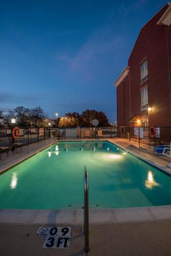 an empty swimming pool at night in front of a building at Holiday Inn Express Hotel & Suites Plano West - Frisco by IHG in Plano