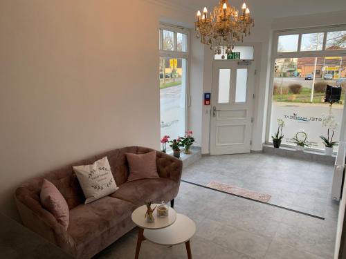 a living room with a couch and a table at Hotel Hanseat Stralsund in Stralsund