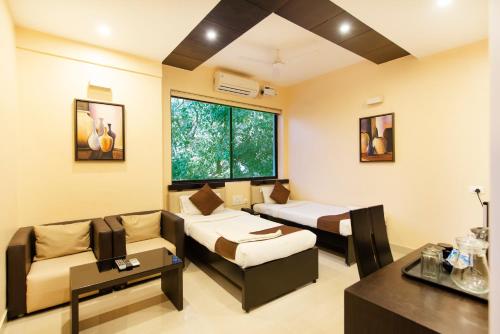 a living room with two beds and a couch at Angson Apartment in Chennai