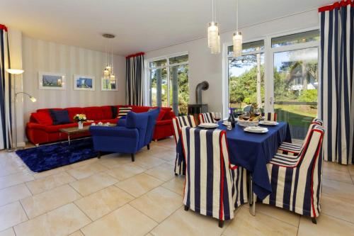 a living room with a table and chairs and a red couch at Lotsenstieg 03 in Ostseebad Karlshagen