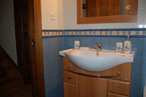 a bathroom with a white sink and blue tiles at Gestiona2R - Casa en Colombres centro in Colombres