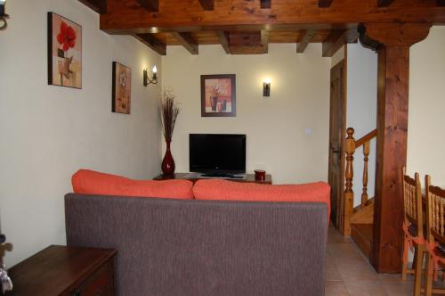 a living room with a couch and a television at Gestiona2R - Casa en Colombres centro in Colombres