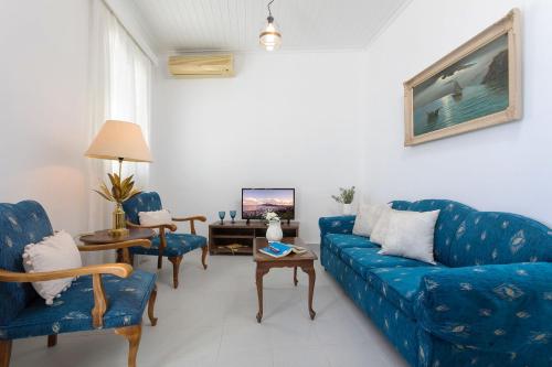 a living room with a blue couch and chairs at Andriani Apartment in Zakynthos