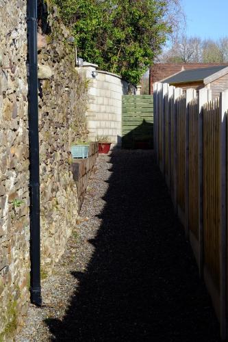 a stone wall and a fence next to a street at Blackwater Eco Pods in Villierstown